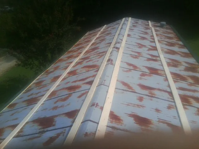 Rusted metal roof panels with new wood purlins before replacement — Storm Damage Roof Repair in Smock by Roofing Brothers