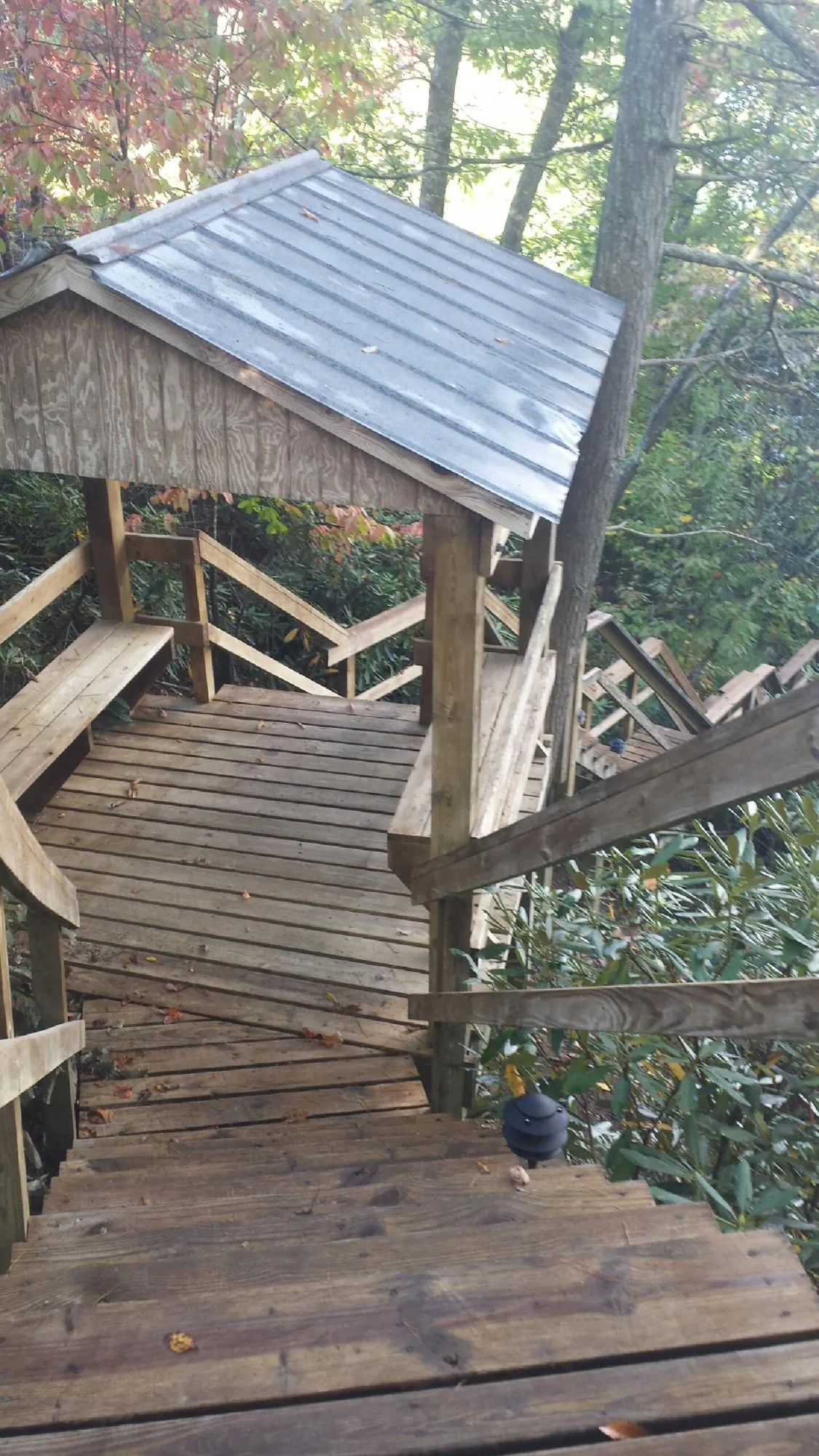 Metal roofed shelter over wooden steps on a wooded walkway — Skylight Repair & Installation work by our crew in Smock