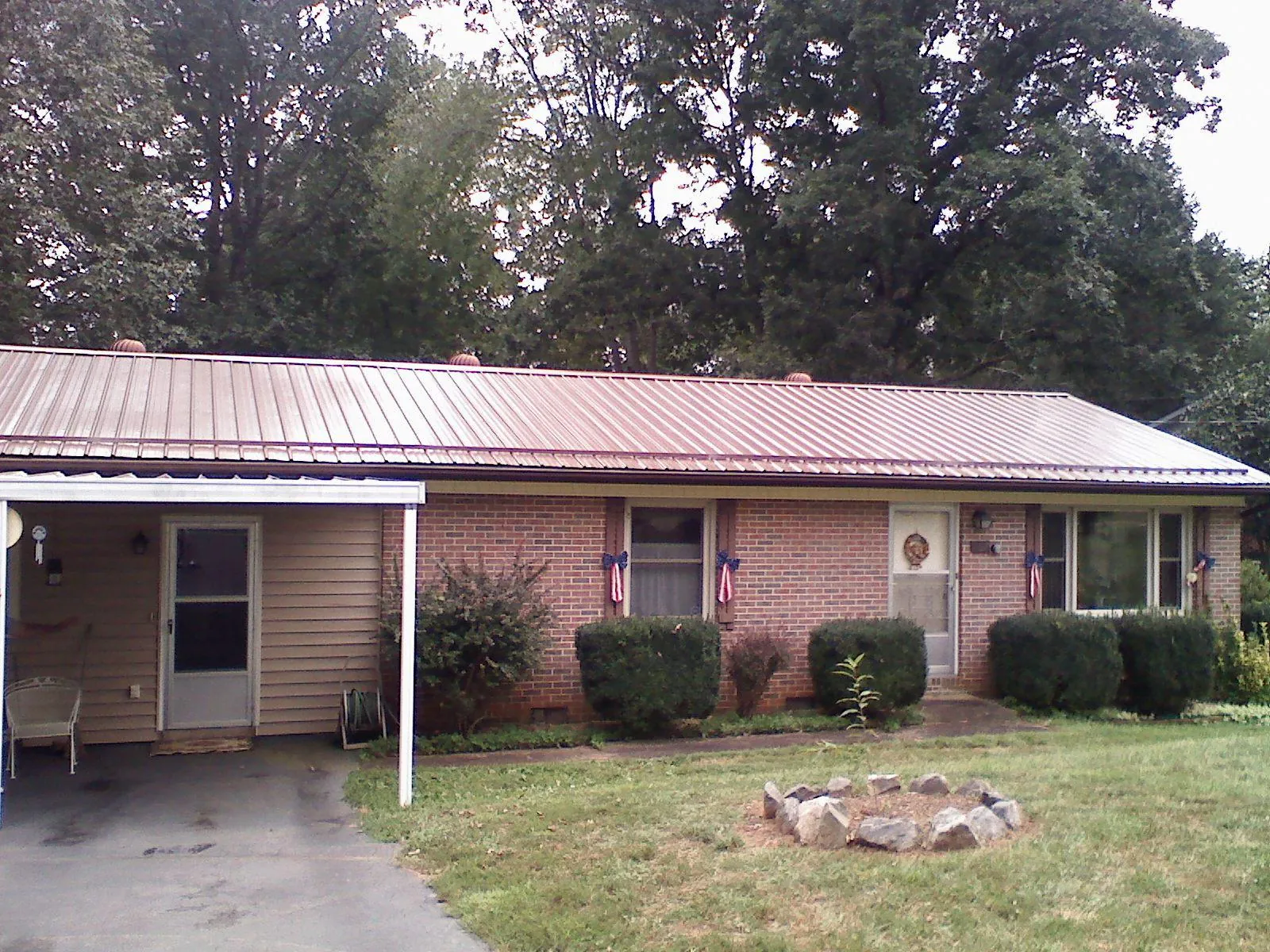 Bronze metal roof and carport on a brick ranch home — Roof Repair work by our crew in Smock