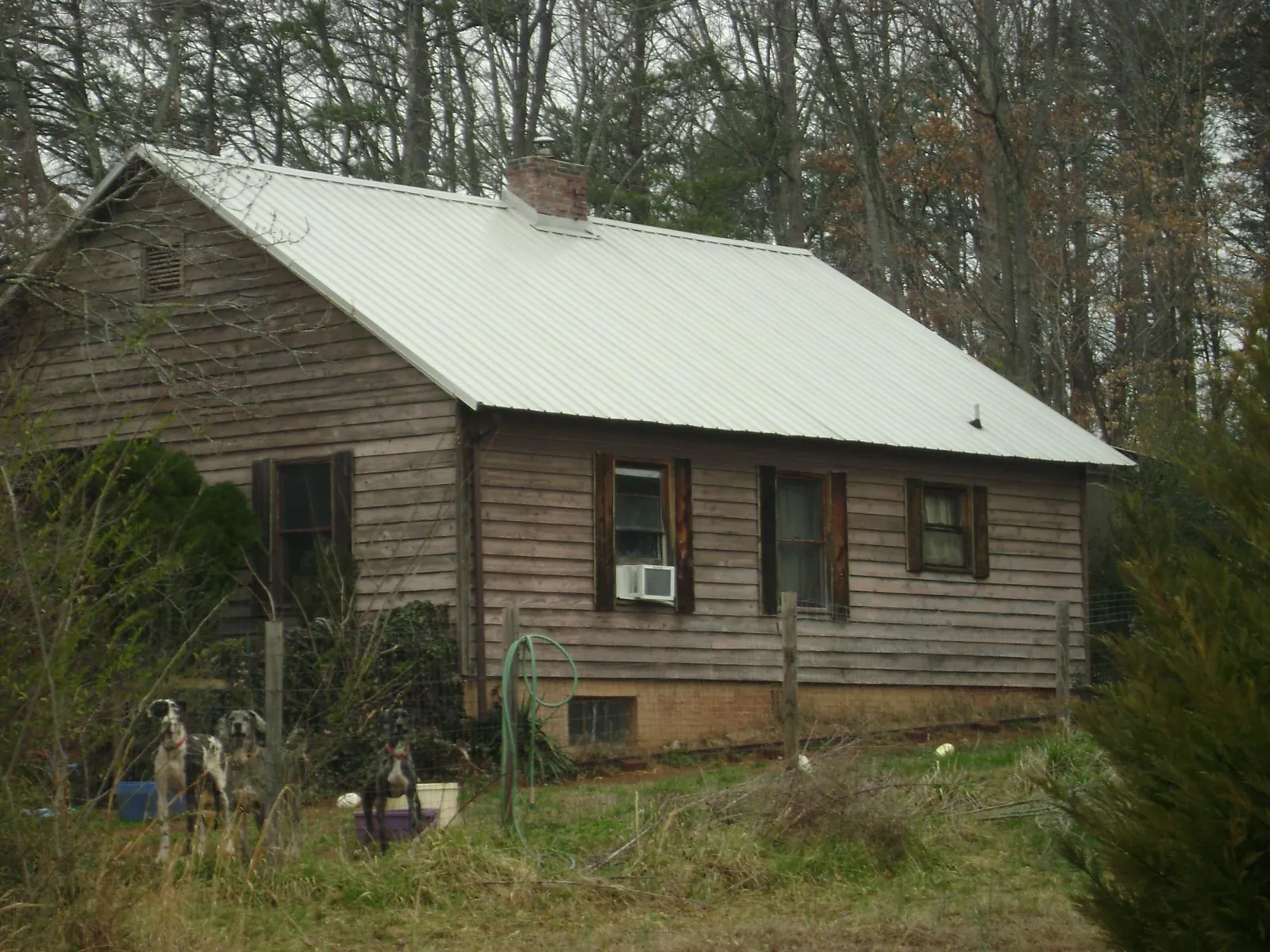 White metal roof on an old wood sided farmhouse, from a Metal Roof Installation job in Smock